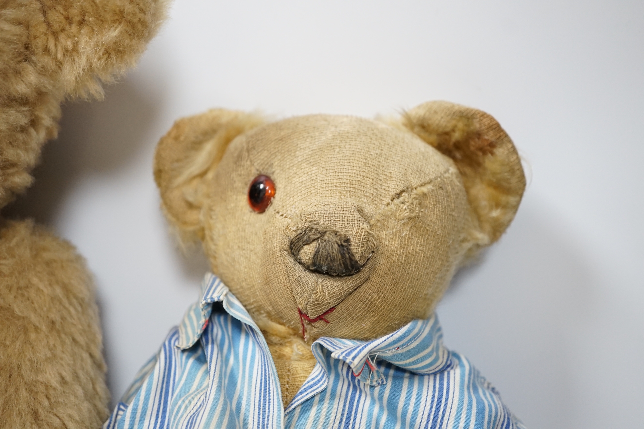 Two Invicta bears, 30cm and 45cm, some wear, and a Merrythought bear, dressed in vintage dressing gown and pyjamas, 32cm high, with hair loss